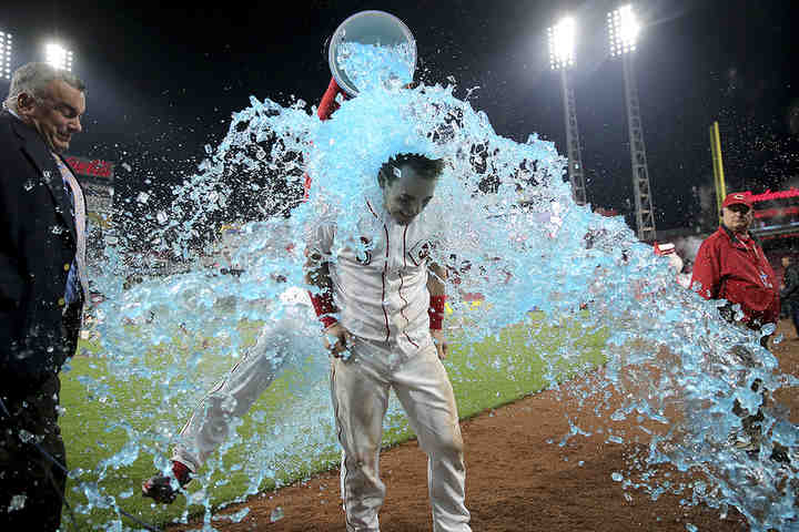 Cincinnati Reds second baseman Scooter Gennett (3) is doused by starting pitcher Sal Romano (47) after hitting a two-run, walk-off home run to give the Reds a 9-7 win against the Atlanta Braves at Great American Ball Park in Cincinnati.   (Kareem Elgazzar / The Cincinnati Enquirer)